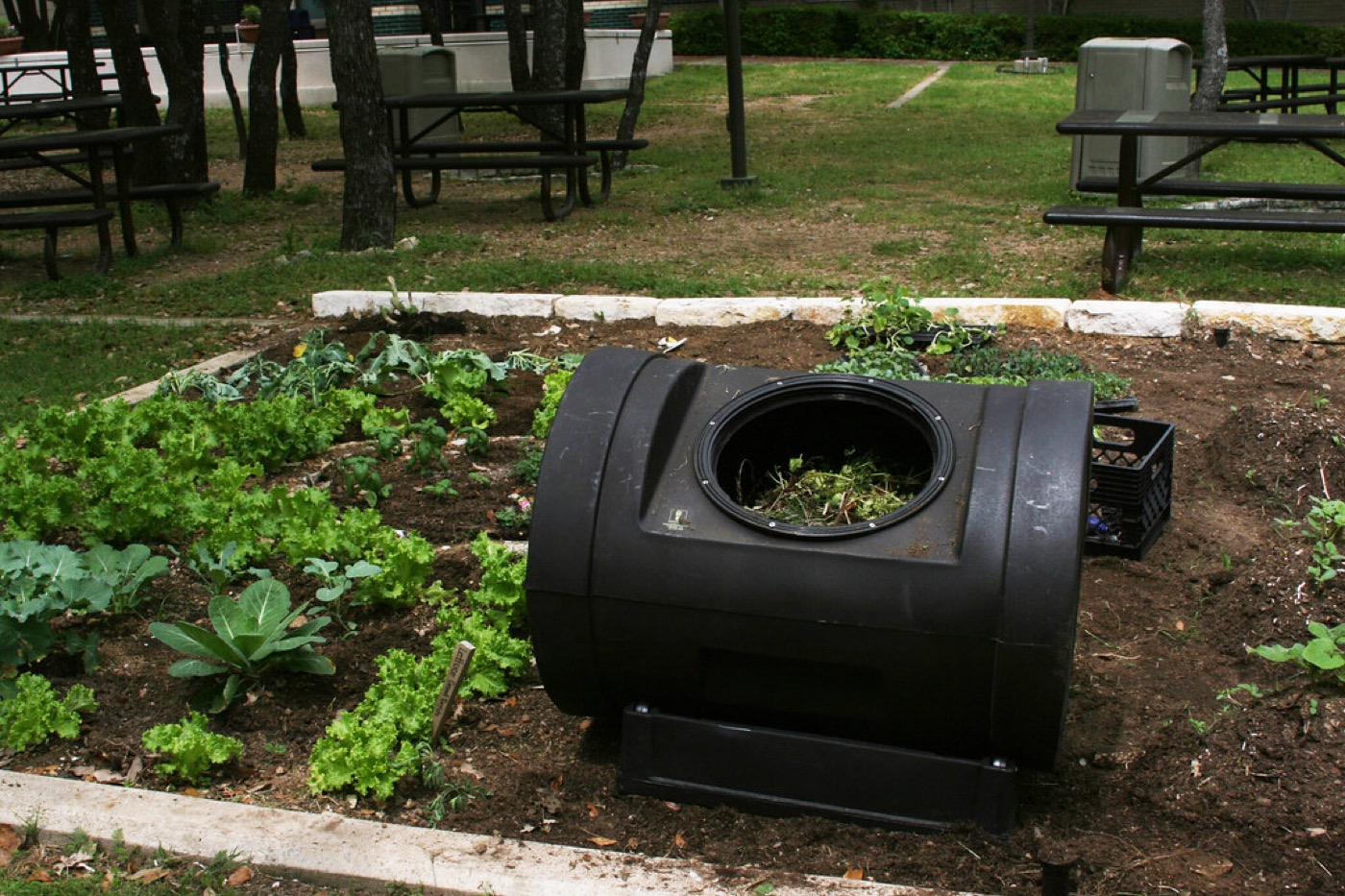 Compostador de jardín con restos vegetales para abono orgánico