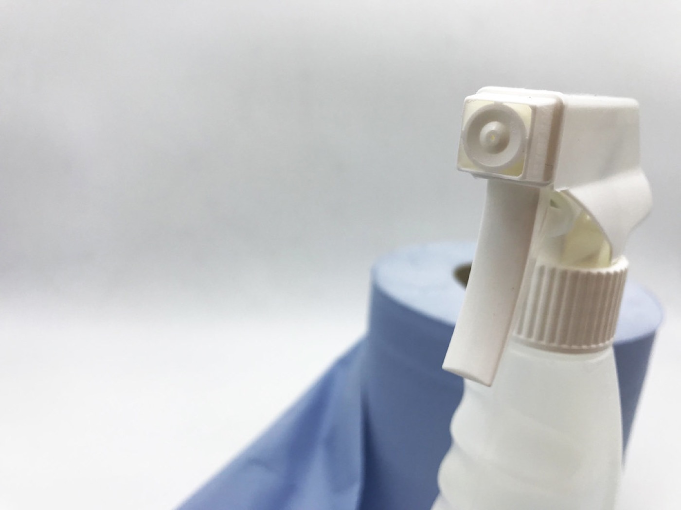 Spray bottle stock photo with blue paper towel in the background