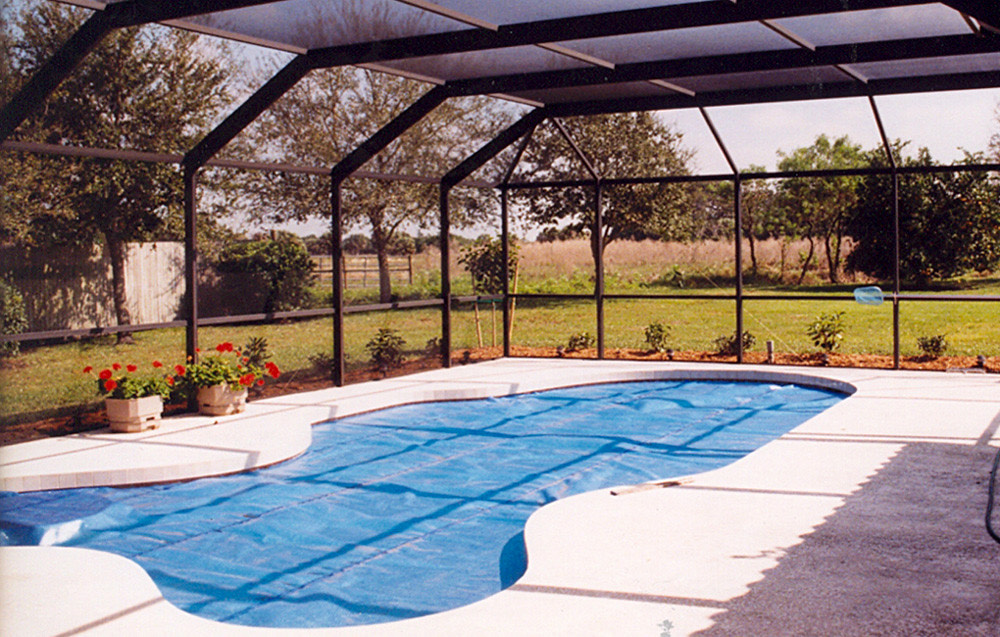 Piscina cubierta con una lona térmica de burbujas dentro de una estructura acristalada