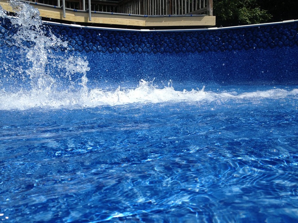 Agua entrando y salpicando en una piscina desmontable con revestimiento de vinilo